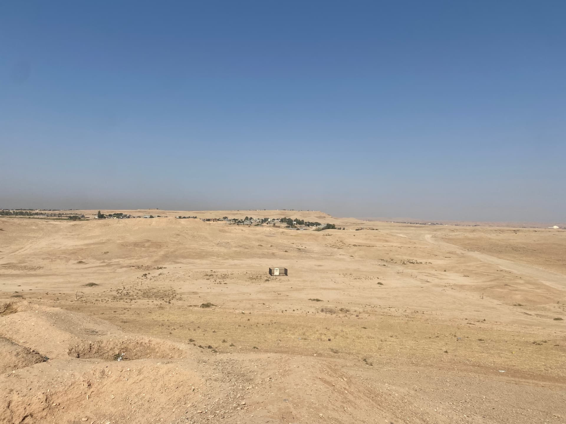 The view from the hill above Khanaqin War Cemetery. The site lies in open desert a few miles from the town, with the fenced central memorial the only structure remaining.