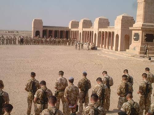 British Army soldiers on patrol at the Basra Memorial to the Missing in 2003, the memorial arches and panel walls intact behind them
