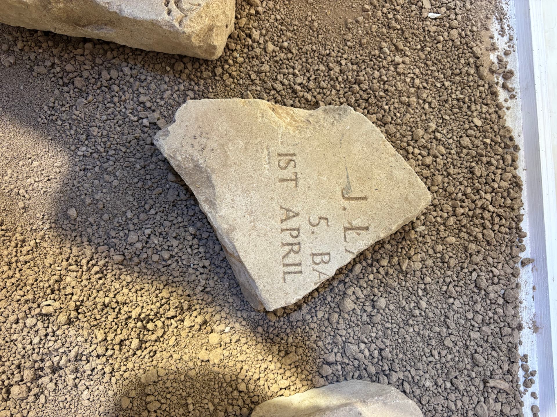 A fragment bearing the initials J. L, the unit 5. Ba, and the date 1st April, part of a Polish soldier's headstone.