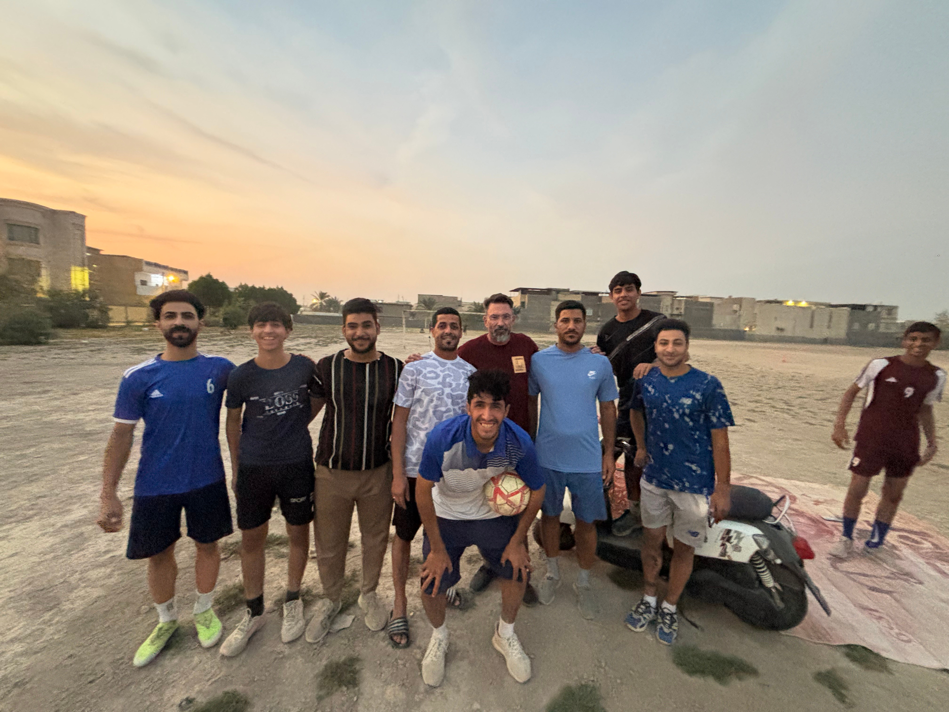 Local community members playing football near Basra War Cemetery