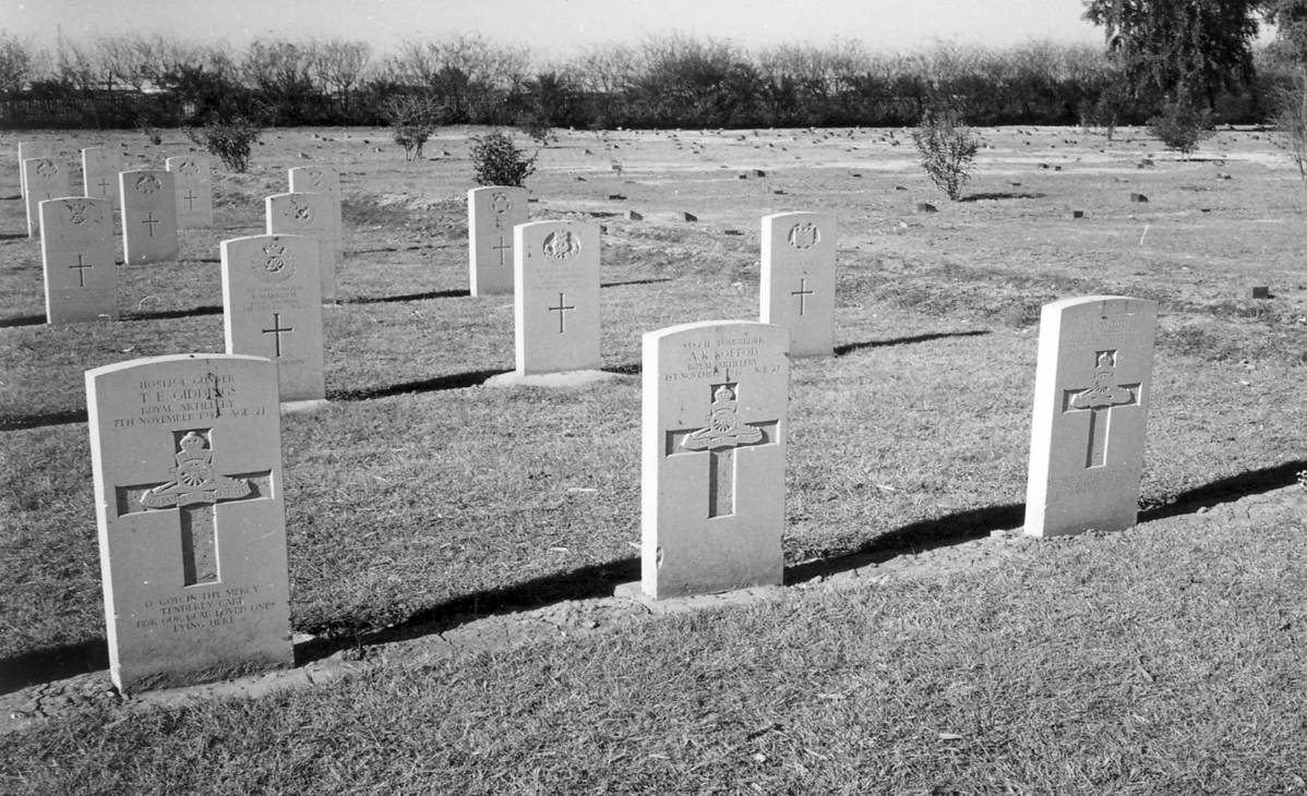 Royal Artillery headstones in the foreground at Basra War Cemetery, including that of Gunner T. E. Giddings, killed 7th November 1941, age 21, with further rows of headstones and open ground extending into the distance. © CWGC.
