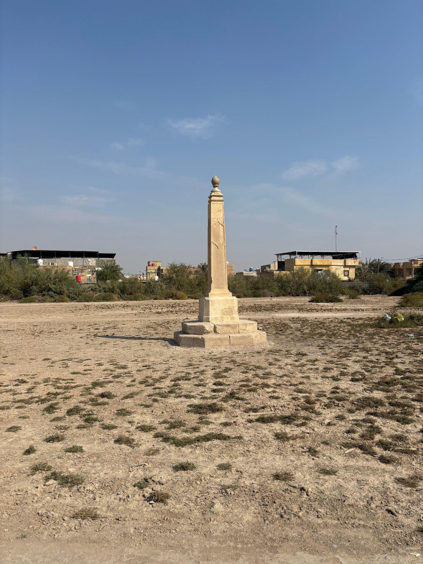 The obelisk on the Indian Forces side of Basra War Cemetery, standing alone on bare, scrub-covered ground where rows of headstones once stood. Photo: Shane Potaka.