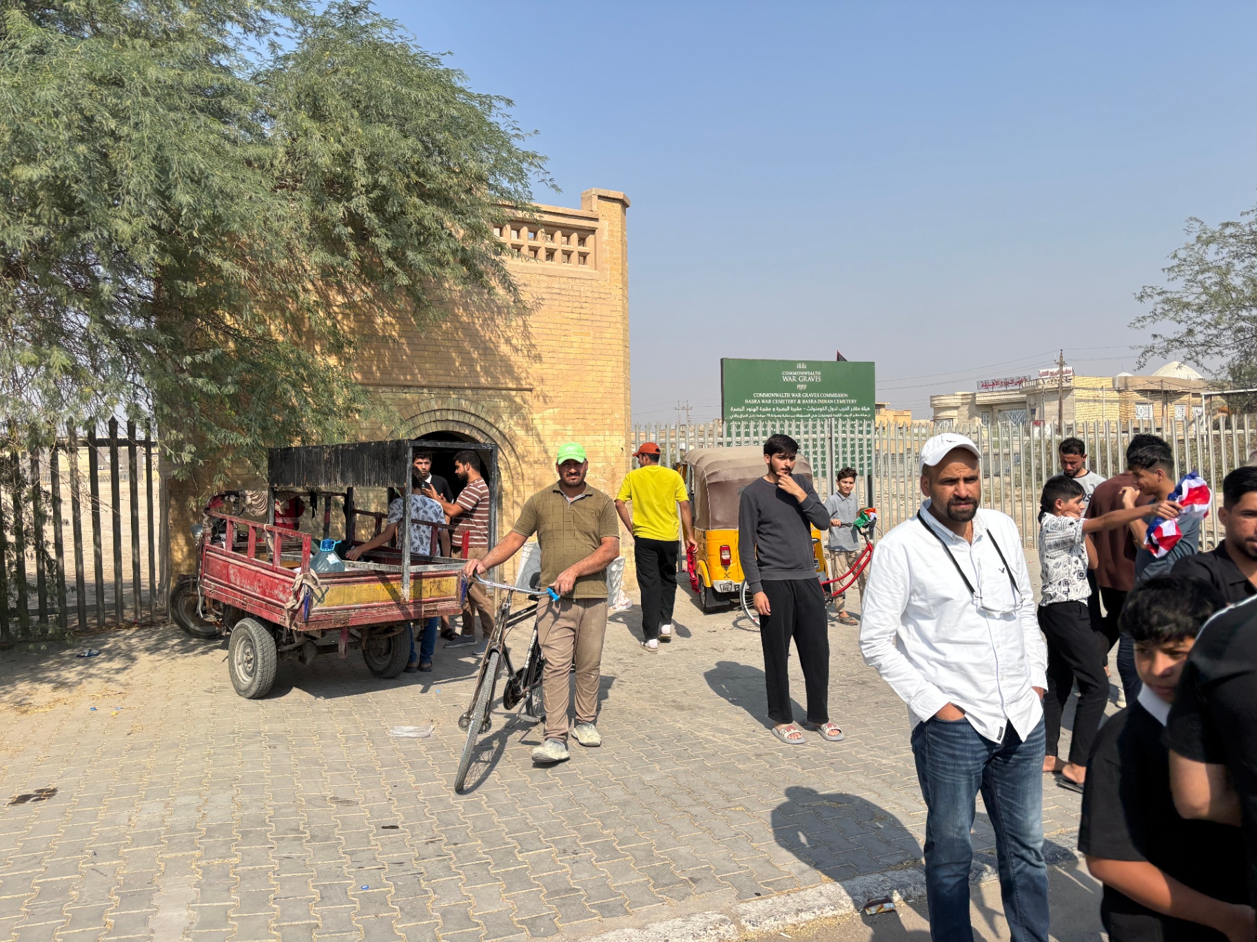 Local community gathering at the entrance to Basra War Cemetery