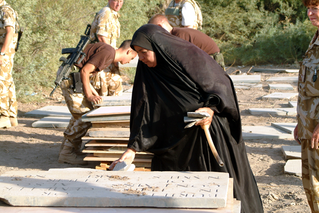 An Iraqi woman cleaning a gravestone during the British Army operation.