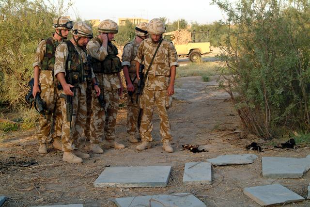 British Army personnel inspecting displaced gravestones at Basra War Cemetery.