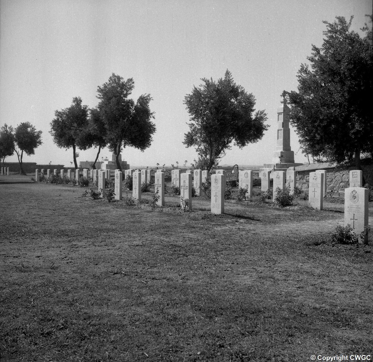 Headstones arranged around one of the Indian memorial obelisks in the maintained cemetery. © CWGC.