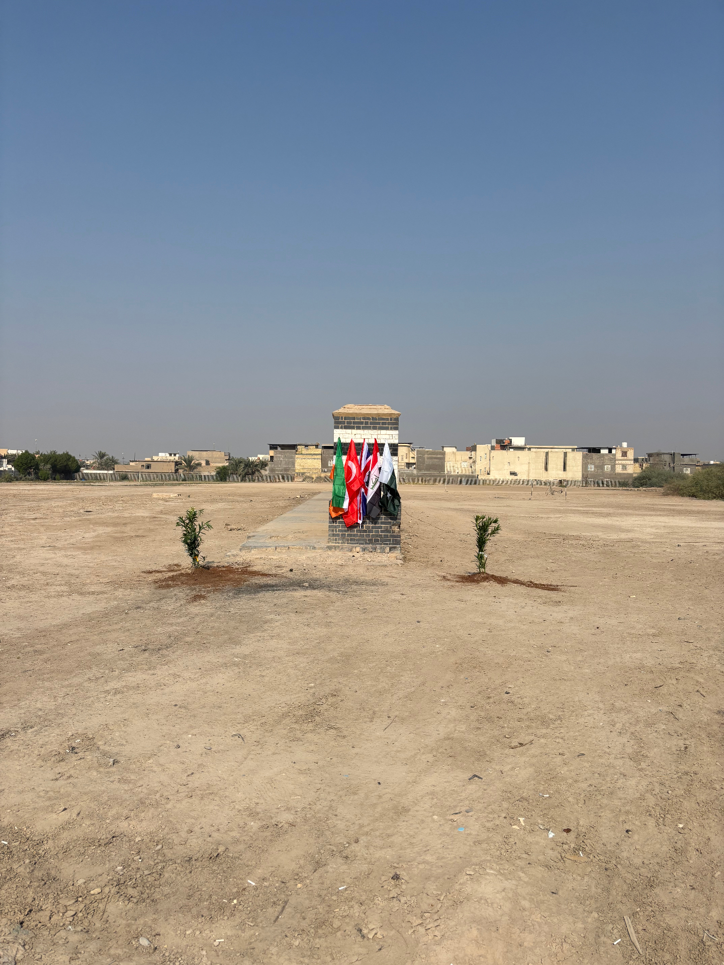 Basra Memorial with Commonwealth flags and newly planted trees during the Remembrance ceremony, 11 November 2025