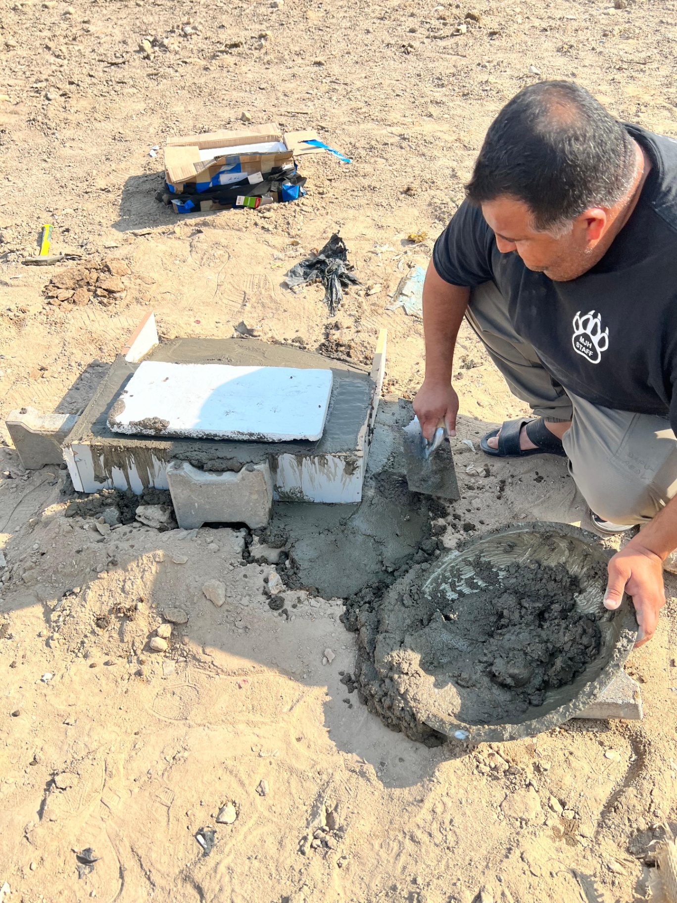 Local helper laying concrete for the gravestone base