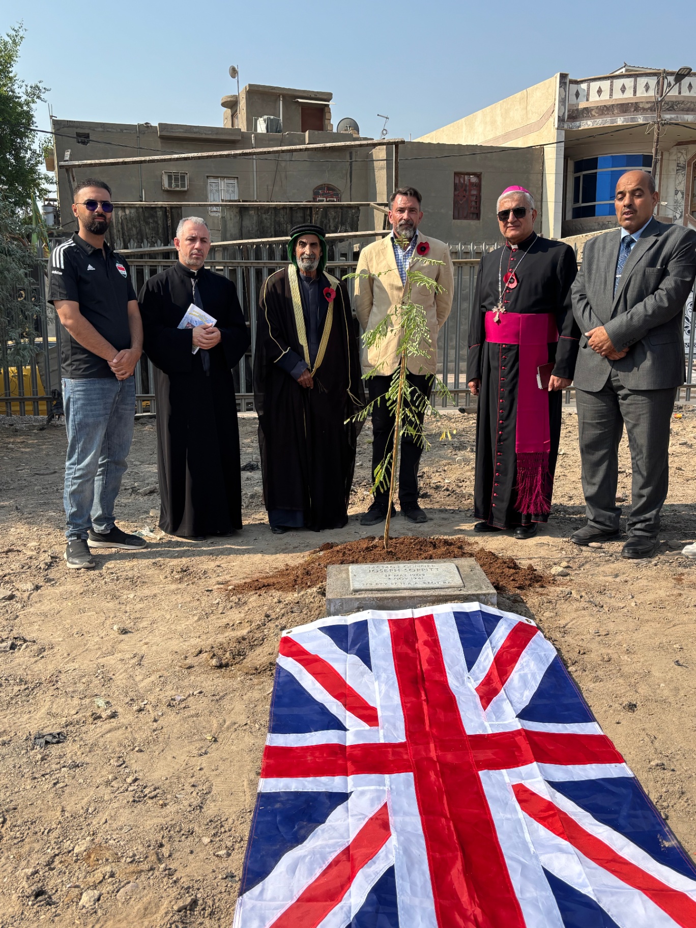 Religious leaders and community members gathered at the gravestone of Gunner Joseph Soppitt with Union Jack flag